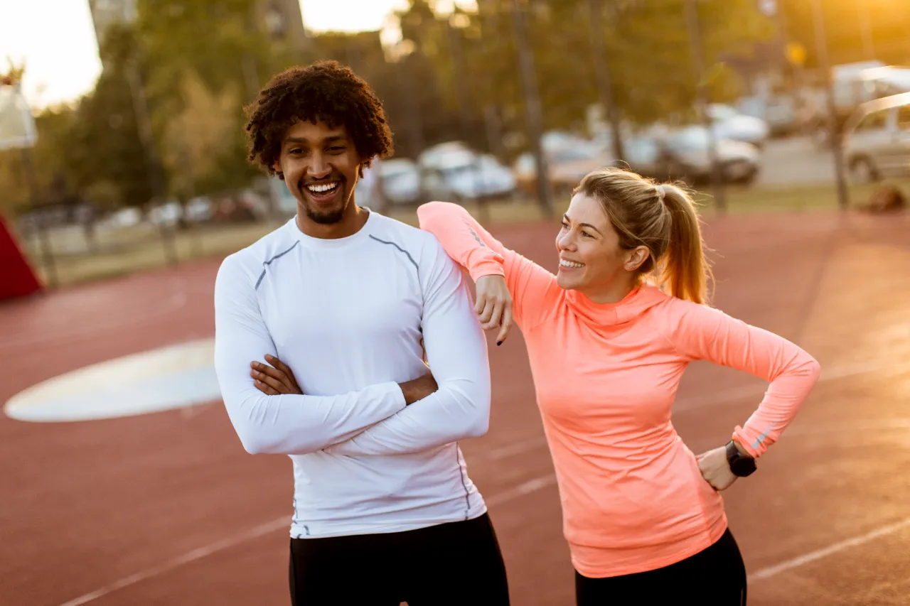 athletic man and woman smiling after workout utc